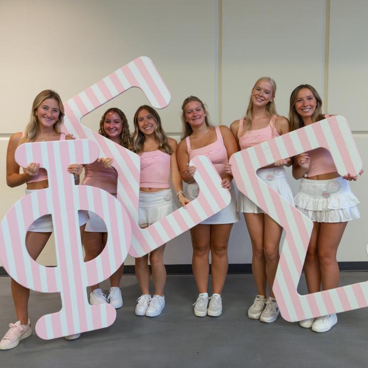 A group of sorority sisters holding their Greek Letters.